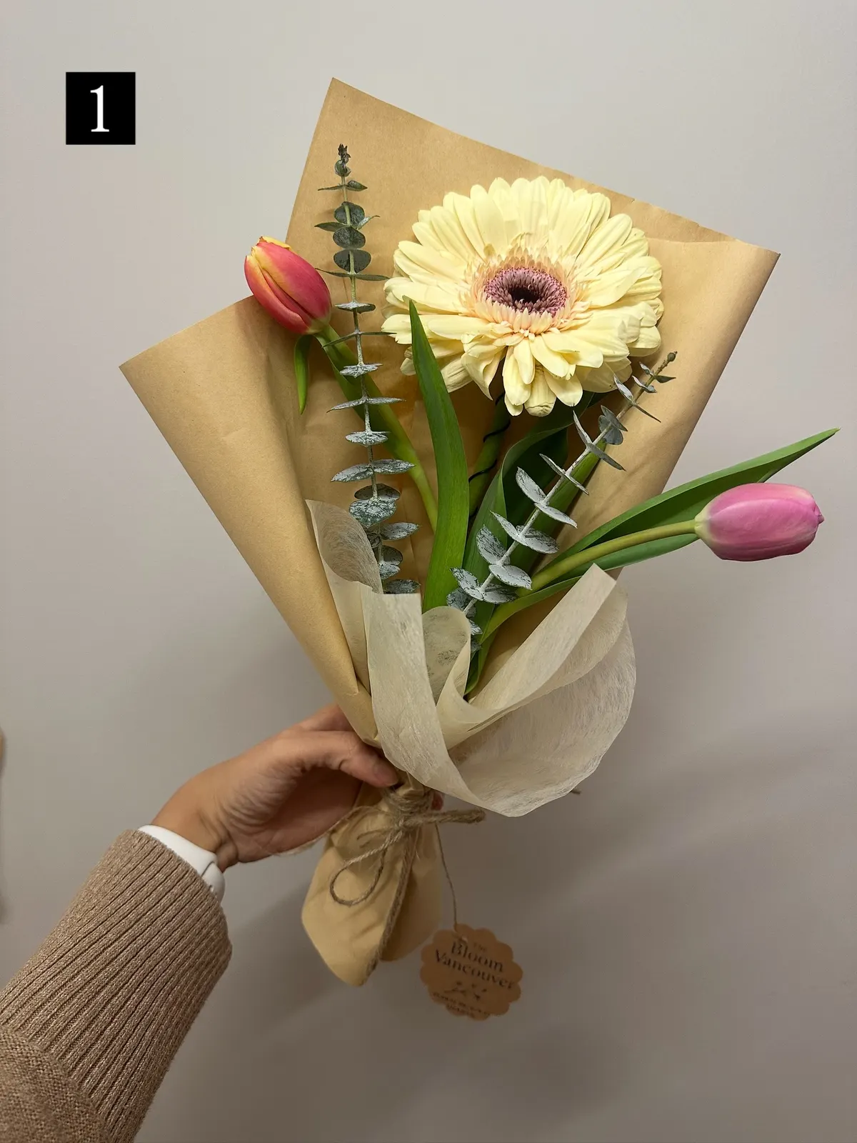Kraft-wrapped bouquet with a cream gerbera and tulips, tagged Bloom Vancouver